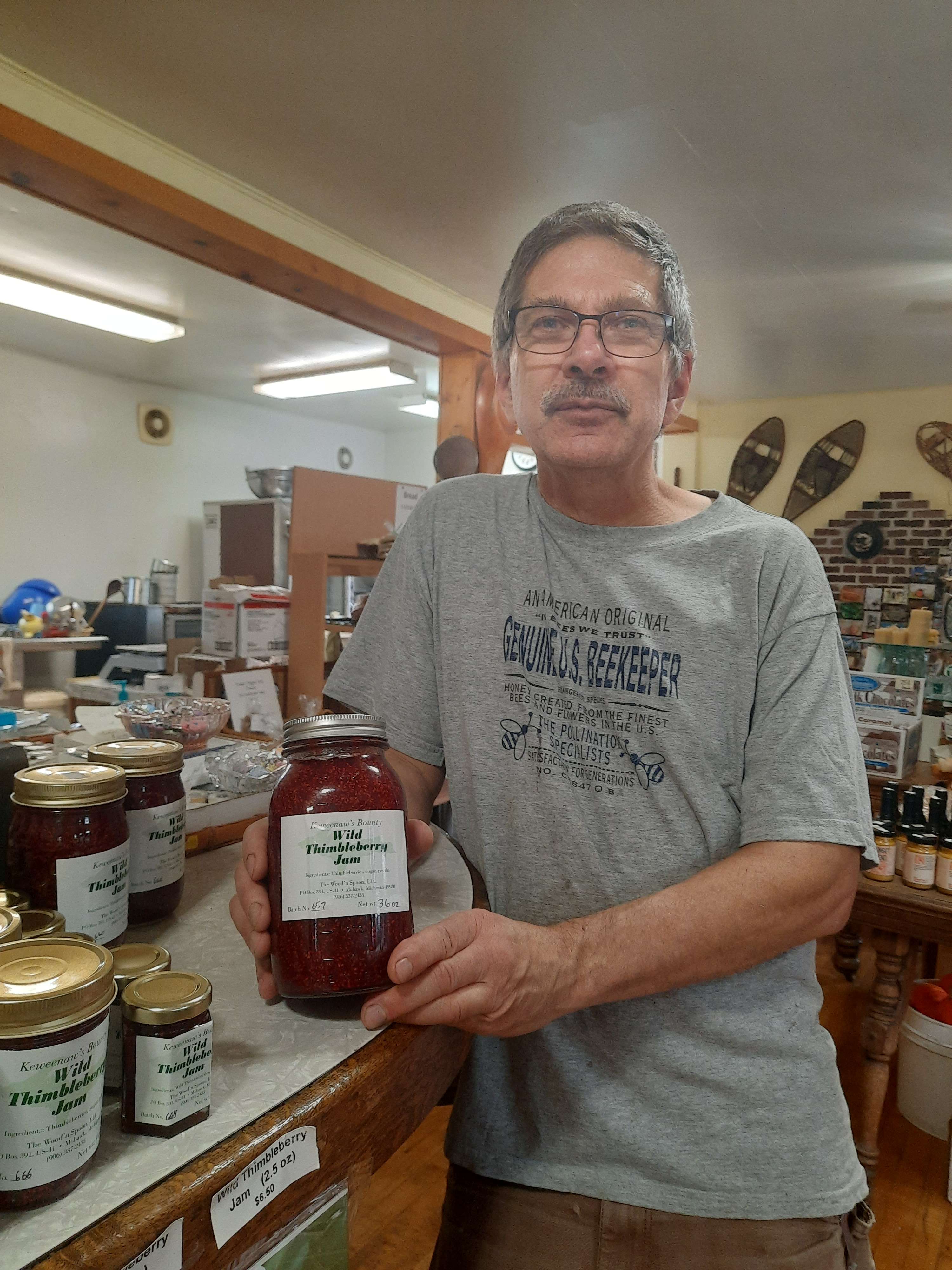 Shop Owner Holding Jar of Thimbleberry Jam